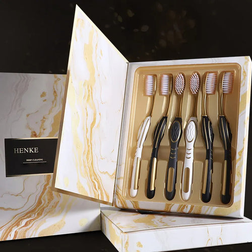 6-pack toothbrush set in open box; black, white and gold handles with soft bristles