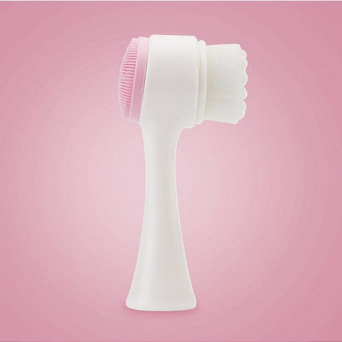 White handheld face cleansing brush with pink bristle head and scalloped back